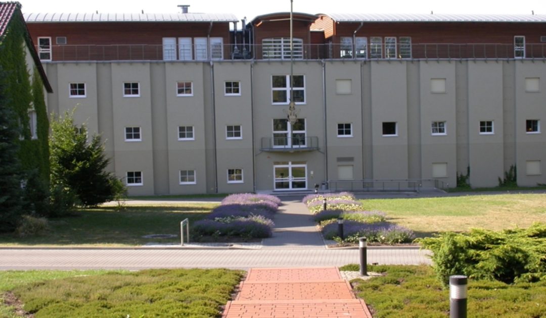 SDEI Institutsgebäude. Blick auf den Haupteingang mit Heuschreckenlogo.